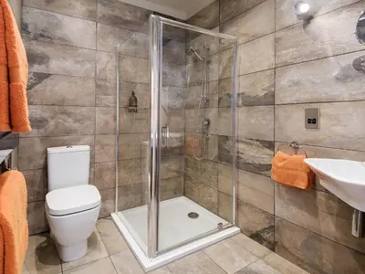 a bathroom with a shower and a toilet and a sink at Willow in Gatehouse of Fleet