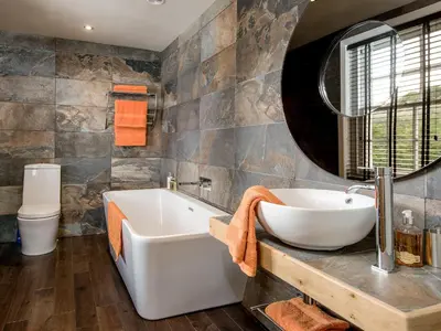 a bathroom with a tub and a sink and a mirror at Willow in Gatehouse of Fleet
