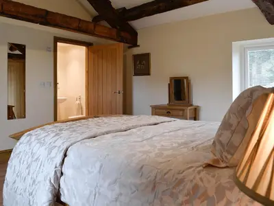 a bedroom with a large bed and a television at The Wheat Shed in Calthwaite