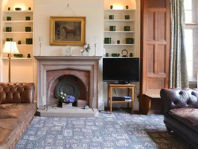 a living room with a fireplace and a television at Blaithwaite House in Blencogo
