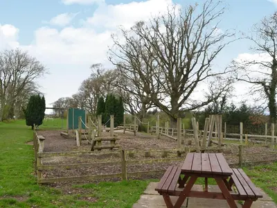 a picnic table in a park next to a fence at Blaithwaite House in Blencogo