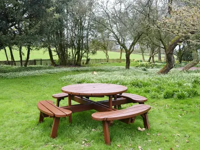 a picnic table and benches in a park at Blaithwaite Stables in Blencogo