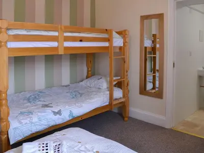 a bunk bed room with two bunk beds and a mirror at Blaithwaite Stables in Blencogo