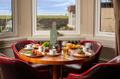 a table with food on it in a room with windows at Fairfield House Hotel in Ayr