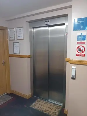 an elevator in a building with a sign on the wall at Quay Head View Aparthotel in Stranraer