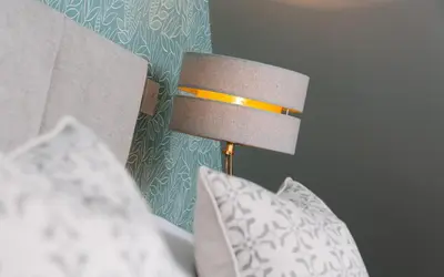 a bed with a lamp and pillows on a bed at Willowbeck Lodge Boutique Hotel in Carlisle