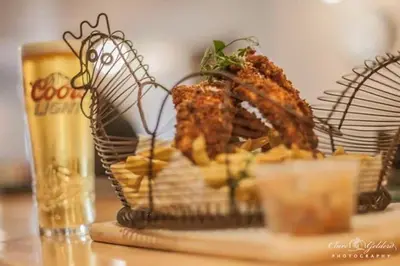 a basket of food on a table with a glass of beer at The Lion and The Lamb in Seascale