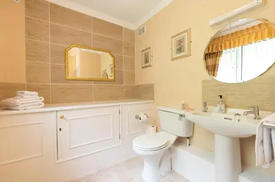 a bathroom with a toilet and a sink and a mirror at The Hill Hotel in Dumfries