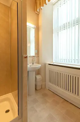 a bathroom with a sink and a toilet and a window at The Hill Hotel in Dumfries