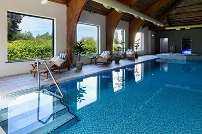 a swimming pool with lounge chairs and a swimming pool at Lake District Castle Inn Hotel & Spa in Keswick