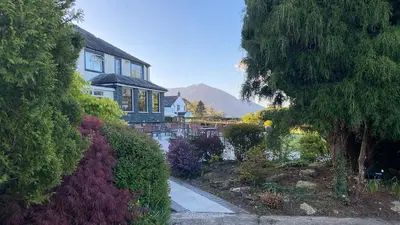 a house with a pond in front of a house at Lake District Castle Inn Hotel & Spa in Keswick