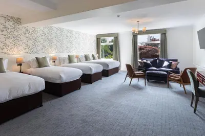 a row of beds in a hotel room at Lake District Castle Inn Hotel & Spa in Keswick