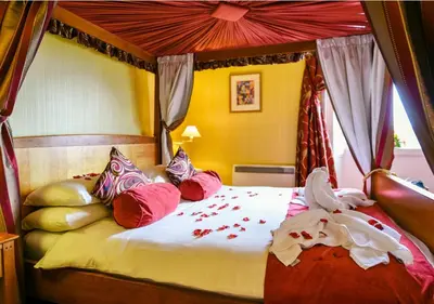 a bedroom with a large bed with red pillows at Cairndale Hotel & Spa in Dumfries