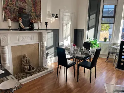 a dining room with a table and a fireplace at Beechwood Ensuite Guest House in Ayr