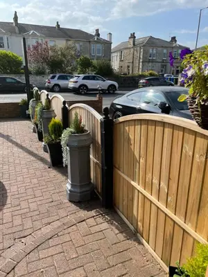 a wooden fence with potted plants on a sidewalk at Beechwood Ensuite Guest House in Ayr