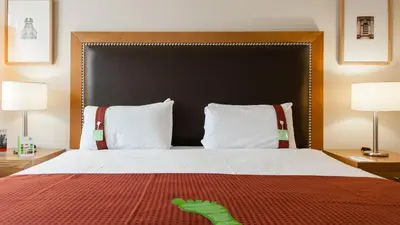 a bedroom with a large bed with two lamps at Holiday Inn Dumfries by IHG in Dumfries