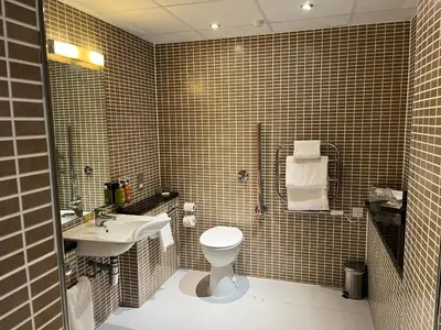 a bathroom with a toilet and a sink at Holiday Inn Dumfries by IHG in Dumfries