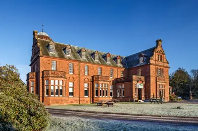 a large brick building with a bench in front of it at Holiday Inn Dumfries by IHG in Dumfries