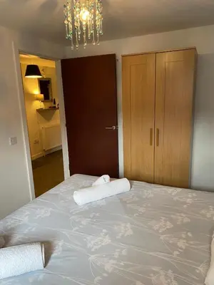 a bedroom with a large bed with two towels on it at Mossie Apartment in Ayr