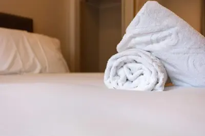 a pile of towels sitting on top of a bed at Harbour House - Donnini Apartments in Ayr