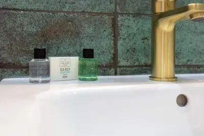 two bottles of soap sitting on top of a bathroom sink at Harbour House - Donnini Apartments in Ayr
