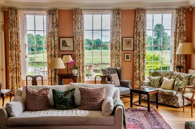 a living room with a couch and windows at Warwick Hall in Carlisle