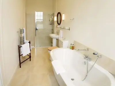 a bathroom with a tub and a toilet and a sink at Warwick Hall in Carlisle