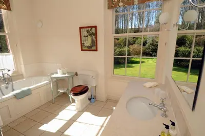 a bathroom with a tub and a toilet and a sink at Warwick Hall in Carlisle