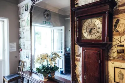 a grandfather clock in a room with a mirror at The Coledale Inn in Keswick