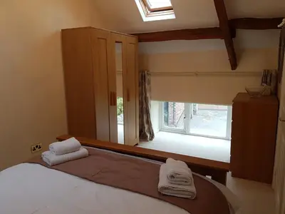 a bedroom with a bed and a window with towels at Green View Lodges in Wigton