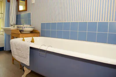 a blue bathroom with a tub and a sink at Lagafater Lodge in Glenwhilly