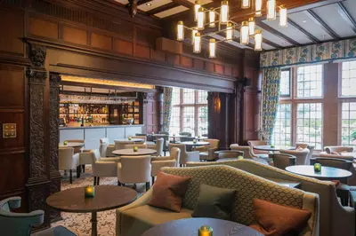 a restaurant with couches and tables and a bar at Piersland House in Troon
