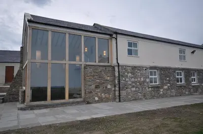 an extension to a house with a stone wall at The Barn at Ballaloaghtan in Ballasalla