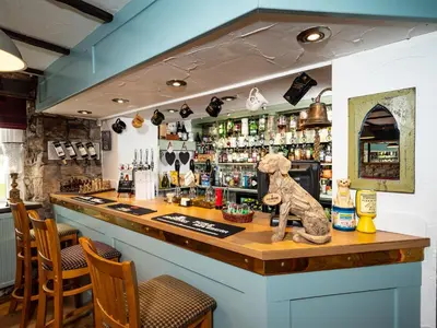 a bar with a bear statue on top of it at Old Posting House in Cockermouth