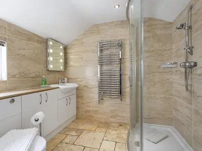 a bathroom with a shower and a toilet and a sink at Tommy's Cottage in Keswick
