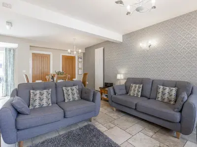 a living room with two blue couches and a room at Tommy's Cottage in Keswick