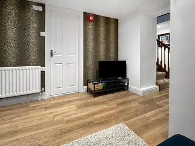 a living room with a flat screen tv and wooden floors at Breckenridge in Keswick