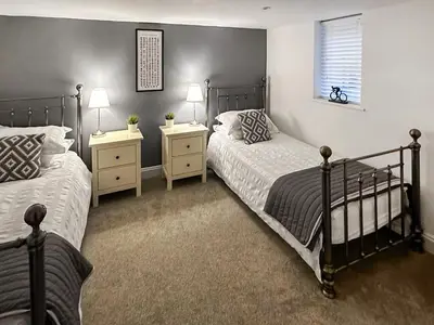 two beds in a bedroom with two lamps and a window at Breckenridge in Keswick