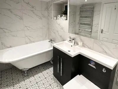 a bathroom with a tub and a sink and a bath tub at Breckenridge in Keswick