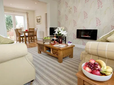 a living room with a bowl of fruit on a table at Elmcot in Keswick