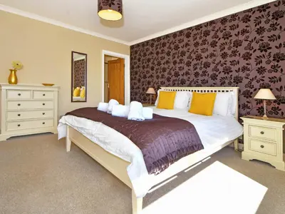 a bedroom with a large white bed with yellow pillows at Holly Bank in Bassenthwaite