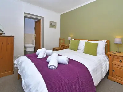 a bedroom with a large bed with towels on it at Holly Bank in Bassenthwaite