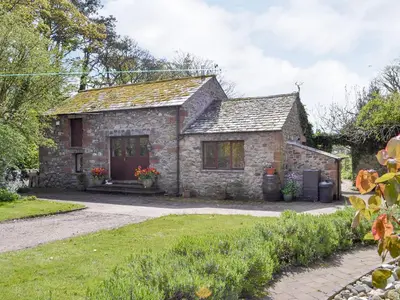 an old stone house with a garden at The Coach House in Corney