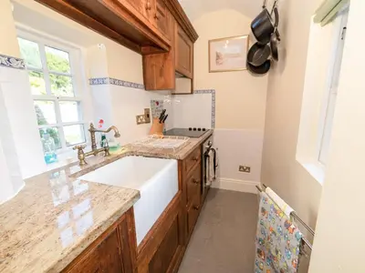 a kitchen with a white sink and a window at Corner House in Lorton