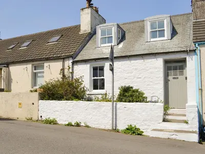 a white house with a white fence at Mill Street in Drummore
