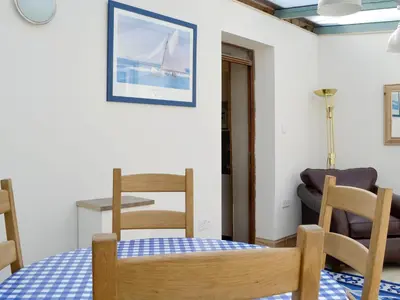 a room with a table and chairs and a couch at Mill Street in Drummore