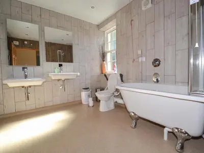 a bathroom with a tub and a toilet and a sink at The Moat House in Annan