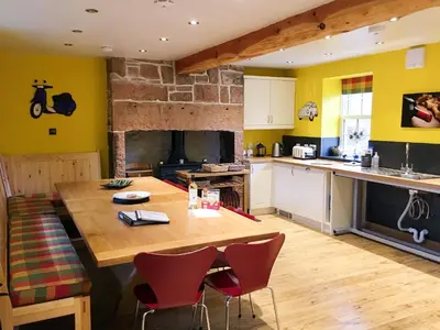 a kitchen with a large wooden table and chairs at The Moat House in Annan