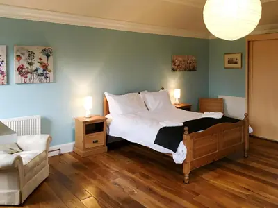 a bedroom with a bed and a couch and a chair at The Moat House in Annan