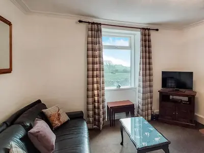 a living room with a couch and a window at Culquhasen in Gillespie